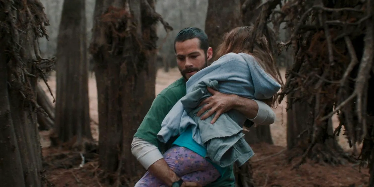 Paris (Dylan O'Brien) carries Anna (Caroline Falk) to safety in 1952 in Caddo Lake Image