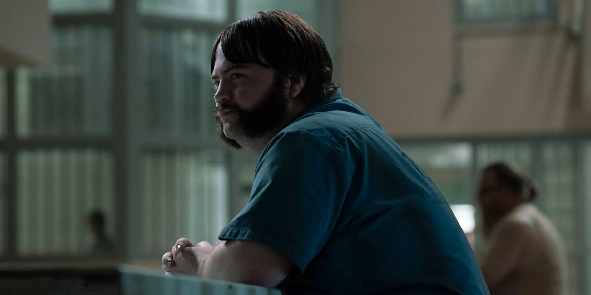 Paul Walter Hauser as Larry Hall sitting at a table in Black Bird_ Image