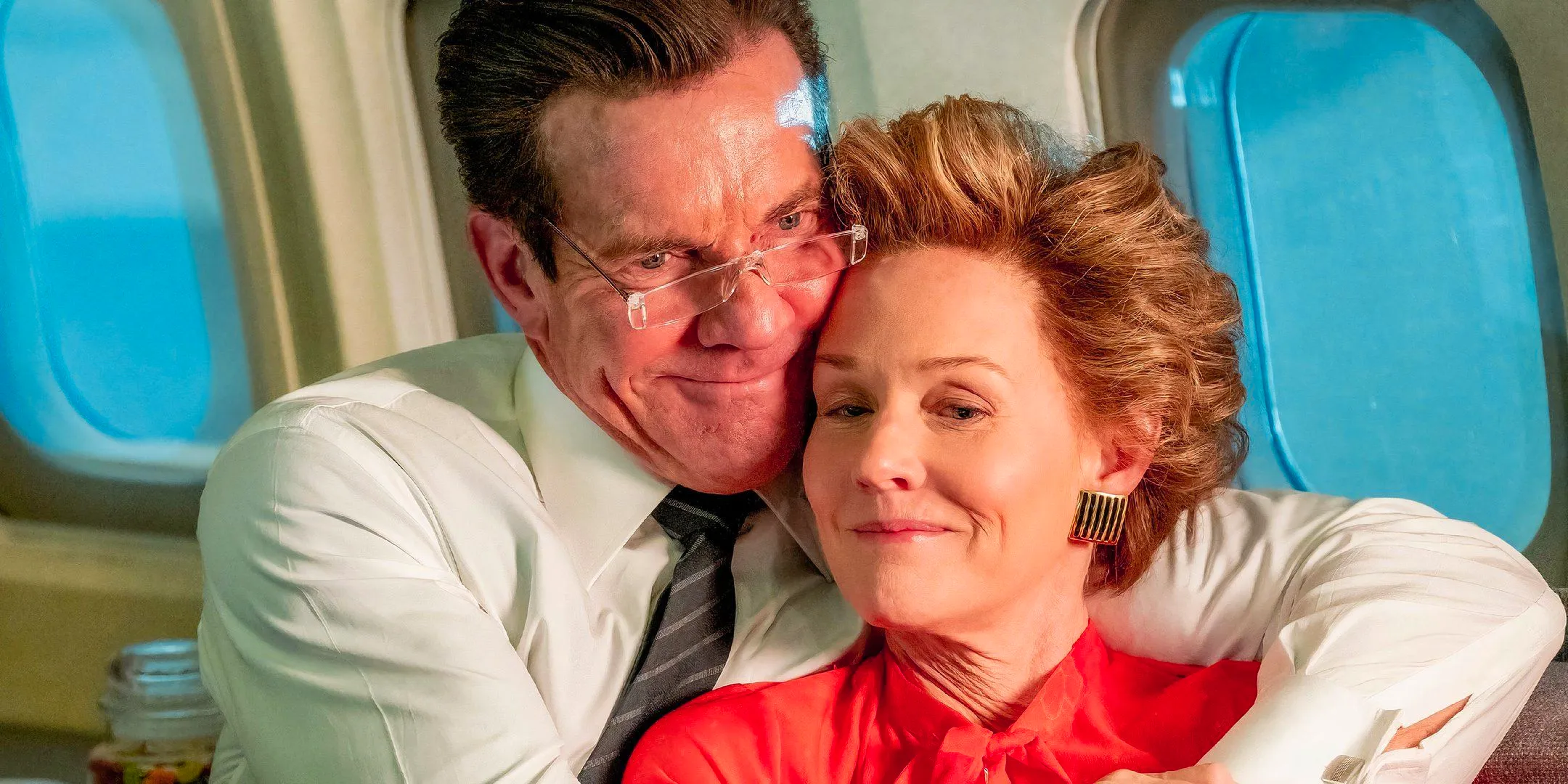 Penelope Ann Miller as Nancy Reagan and Dennis Quaid as Ronald Reagan hugging in a plane in Reagan 2024 Image