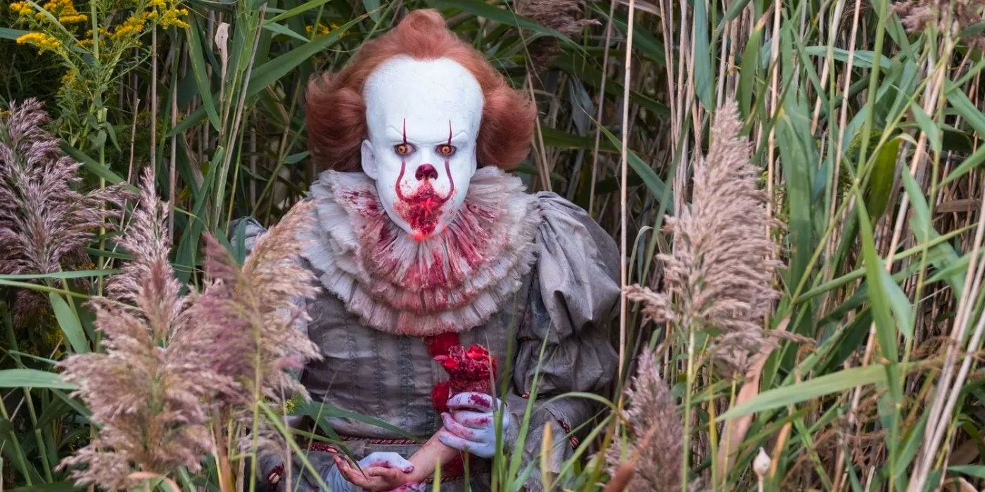 Pennywise the clown eating a human arm in IT Image