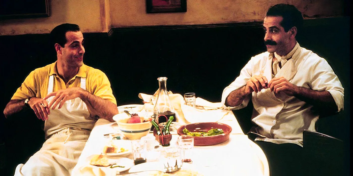 Primo (Tony Shalhoub) and Secondo (Stanley Tucci) laughing over a messy dinner table in Big Night. Image