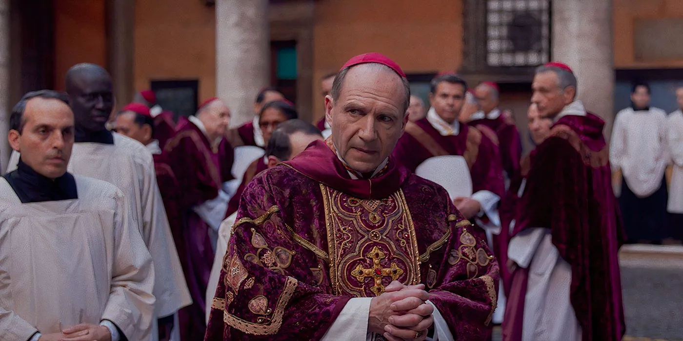 Ralph Fiennes stands in a church in Conclave still Image