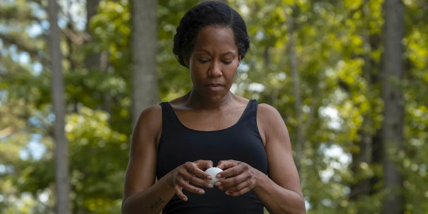 Regina King cracking an egg by the pool in Watchmen Image