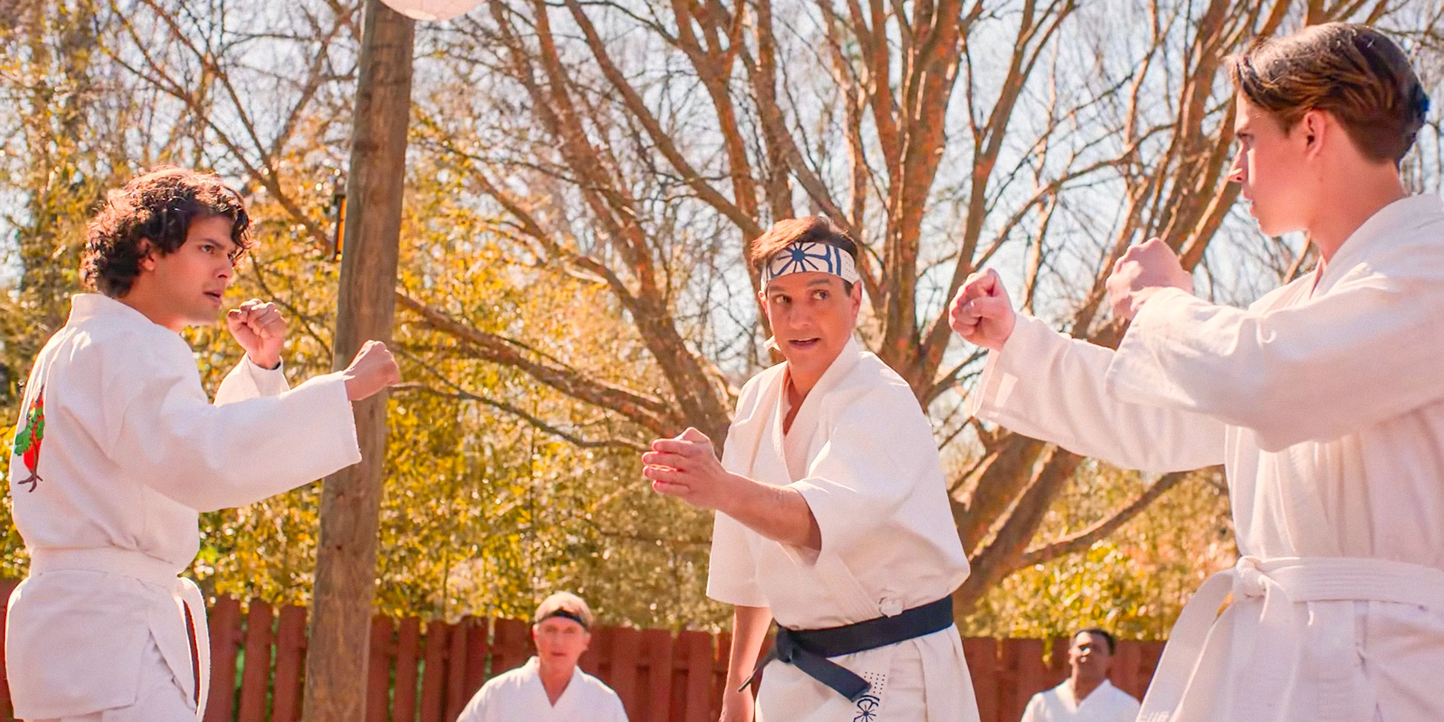 Robby Keene (Tanner Buchanan) and Miguel (Xolo Maridueña) in a fight to become team captain, with Daniel LaRusso (Ralph Macchio) as the referee in Cobra Kai season 6 Image