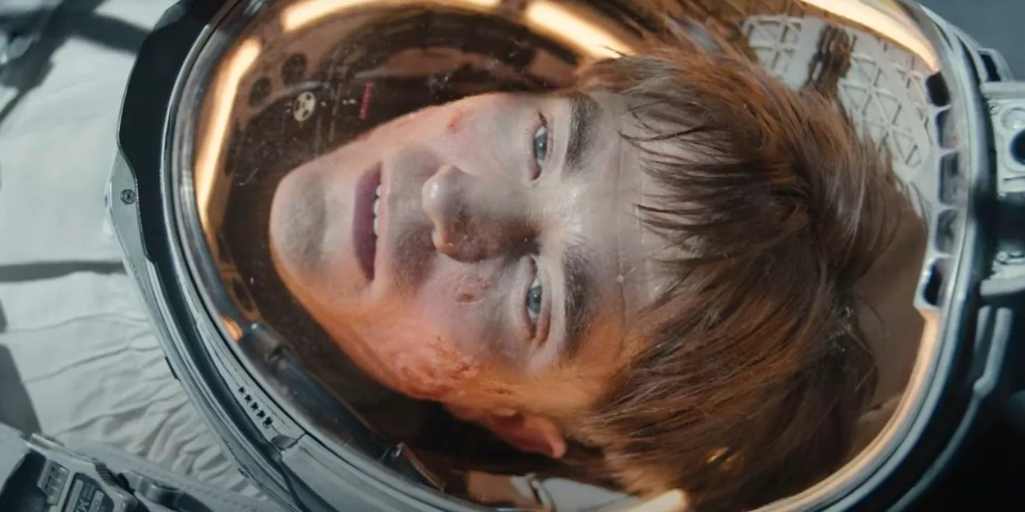 Robert Pattinson in a space suit and looking dazed in Mickey 17 Image