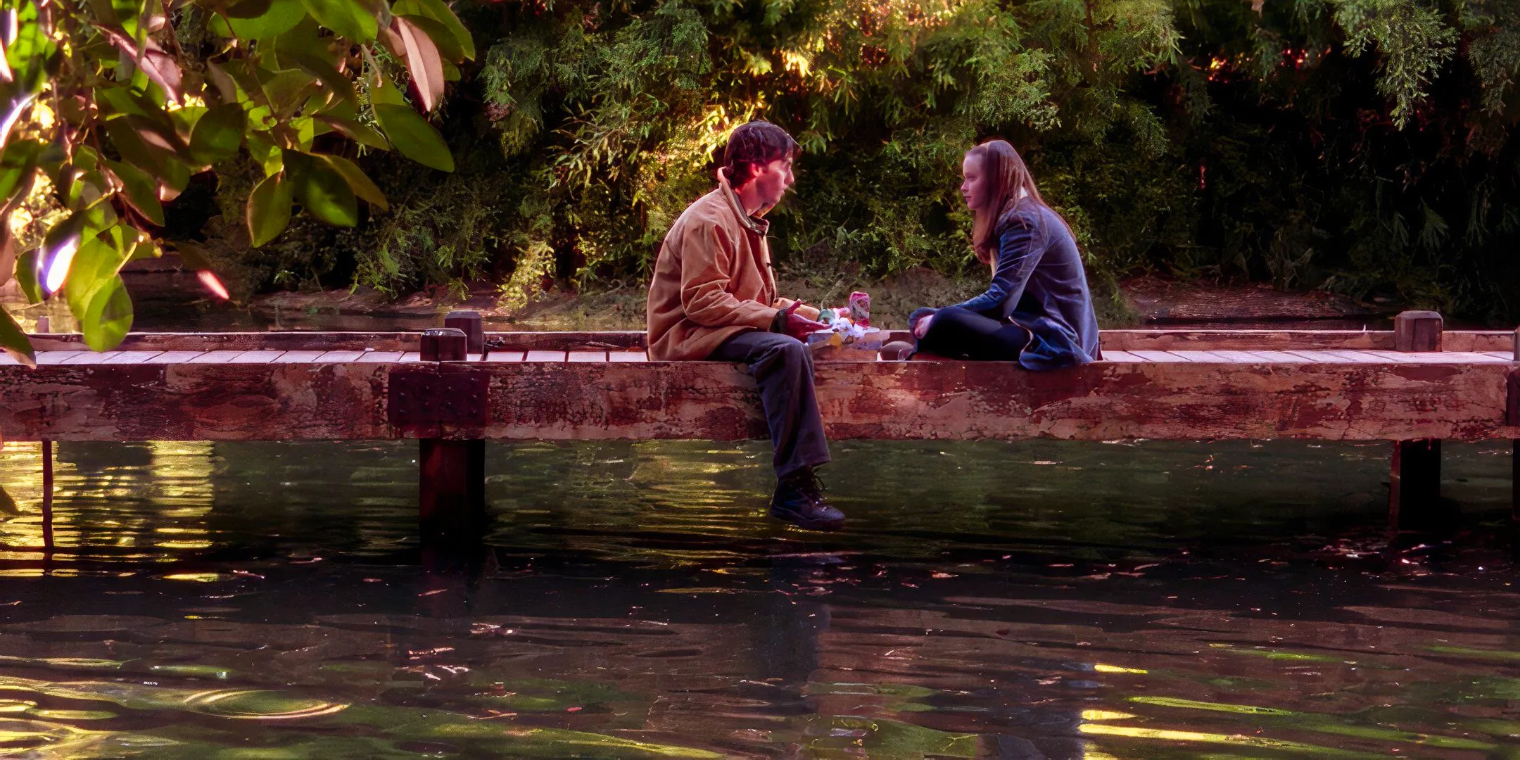 Rory (Alexis Bledel) and Jess (Milo Ventimiglia) sitting talking by the lake in Gilmore Girls Image