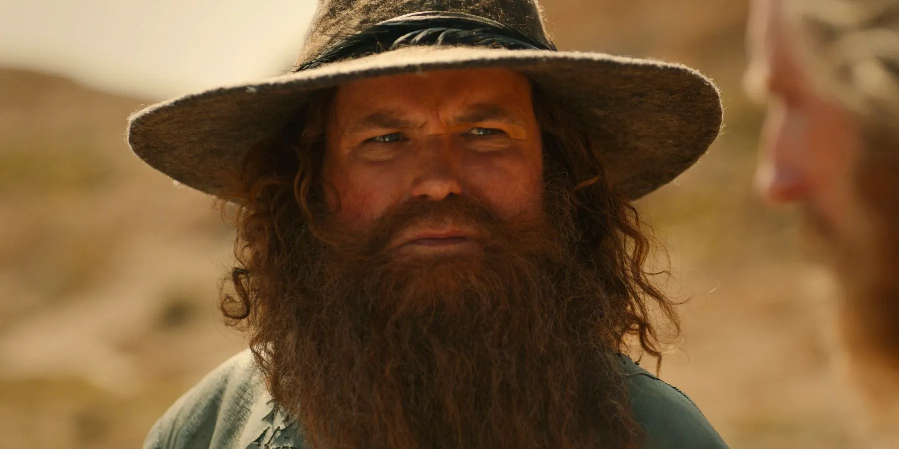 Rory Kinnear as Tom Bombadil looking to the side with concern in The Lord of the Rings: The Rings of Power season 2. Image