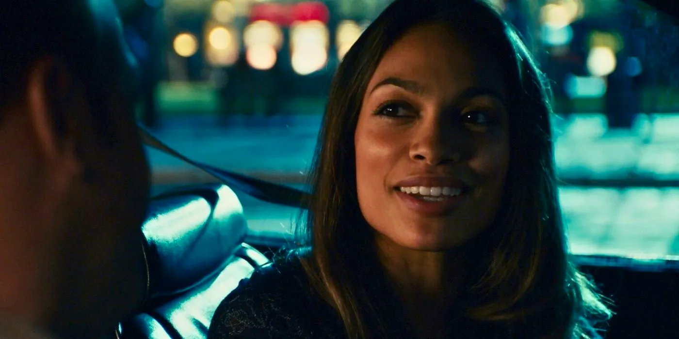 Rosario Dawson as Kate looking sideways and smiling in a car in Zoookeeper Image