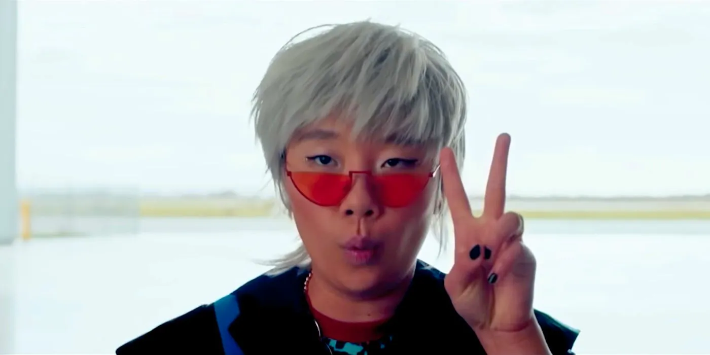 Sabrina Wu as Deadeye holding up the Peace Sign and wearing orange sunglasses in Joy Ride Image