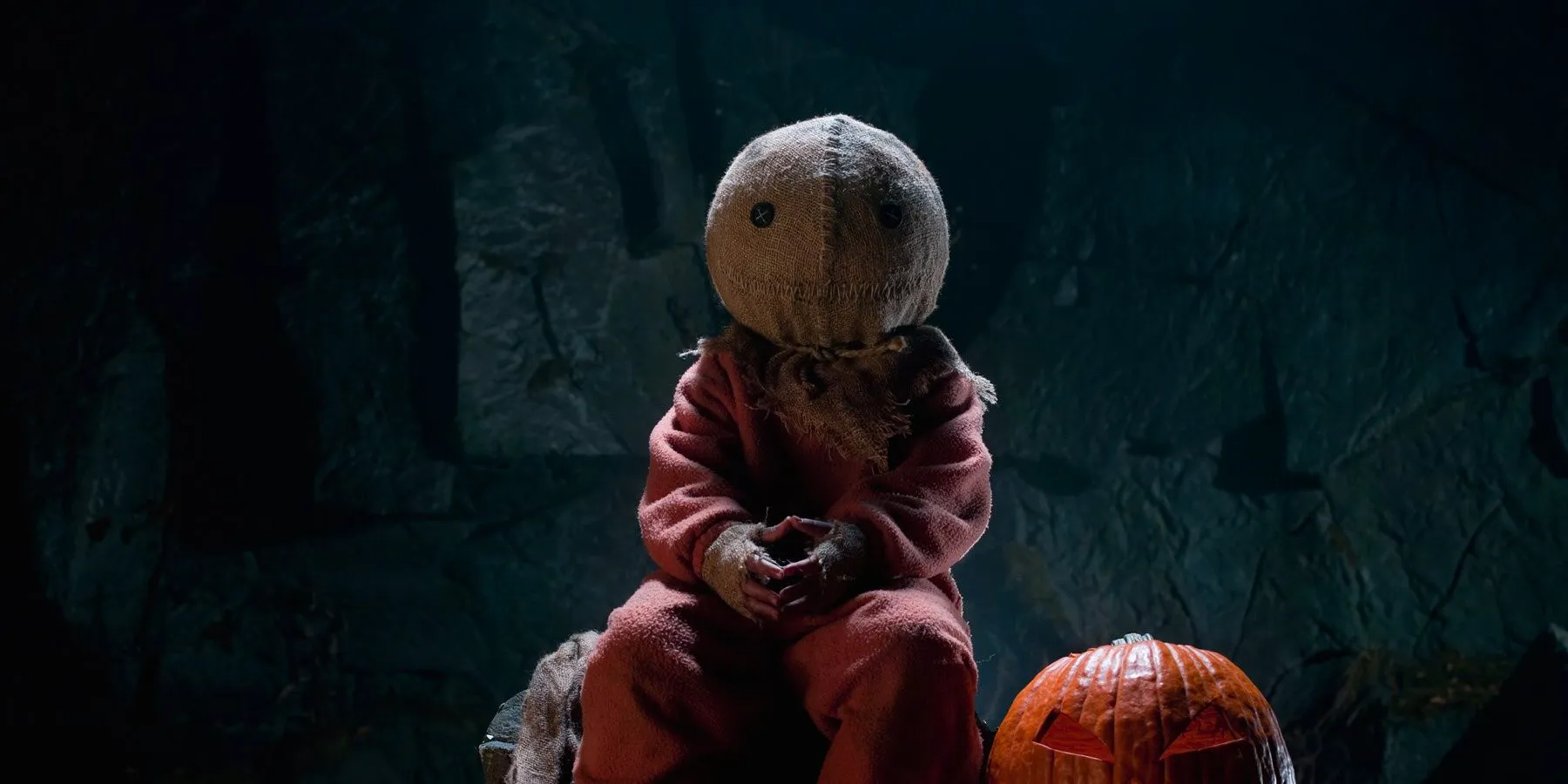 Sam sitting next to a pumpkin in Trick 'R Treat Image