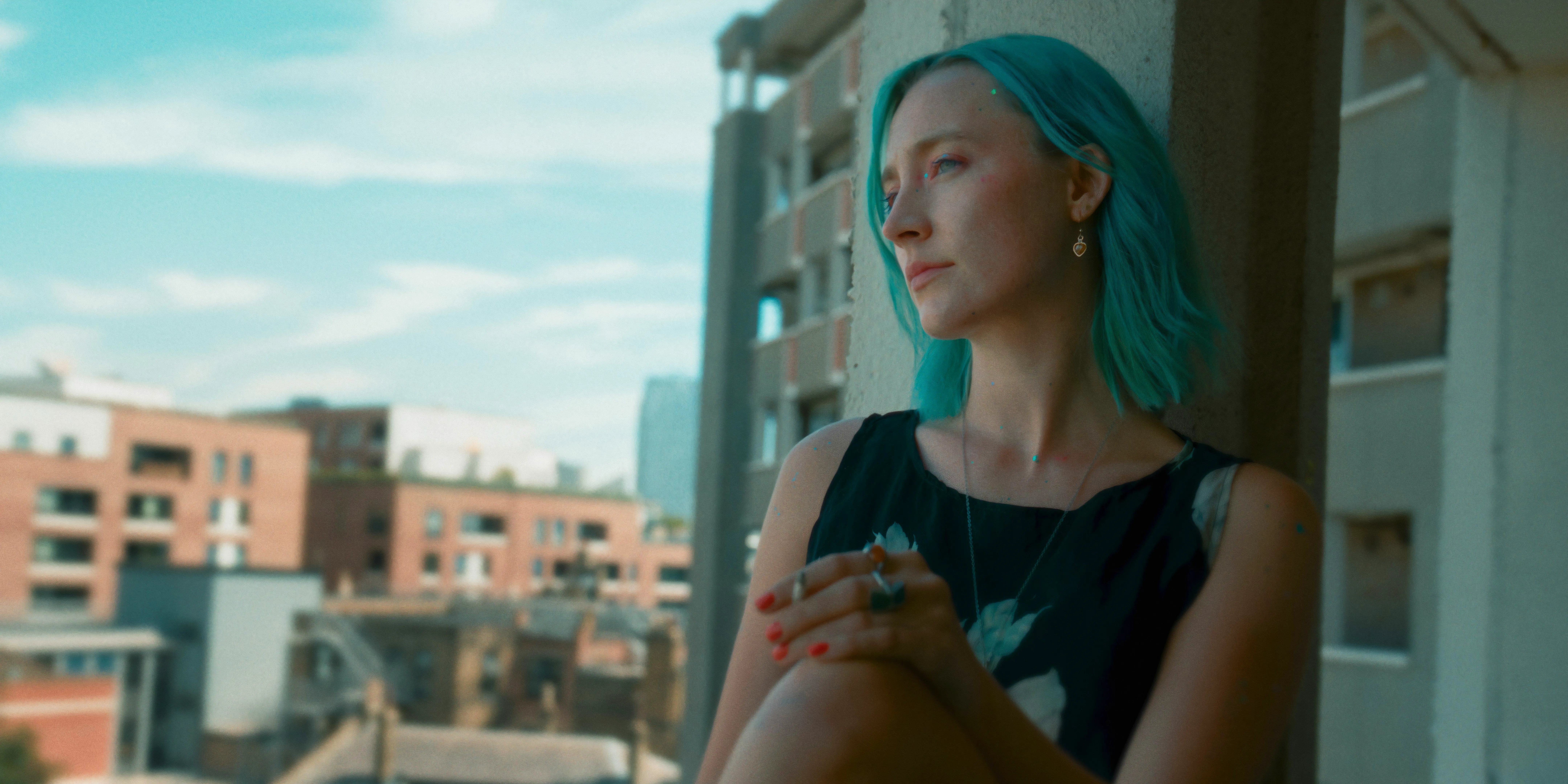 Saoirse Ronan smokes a cigarette while looking out a window in The Outrun Image