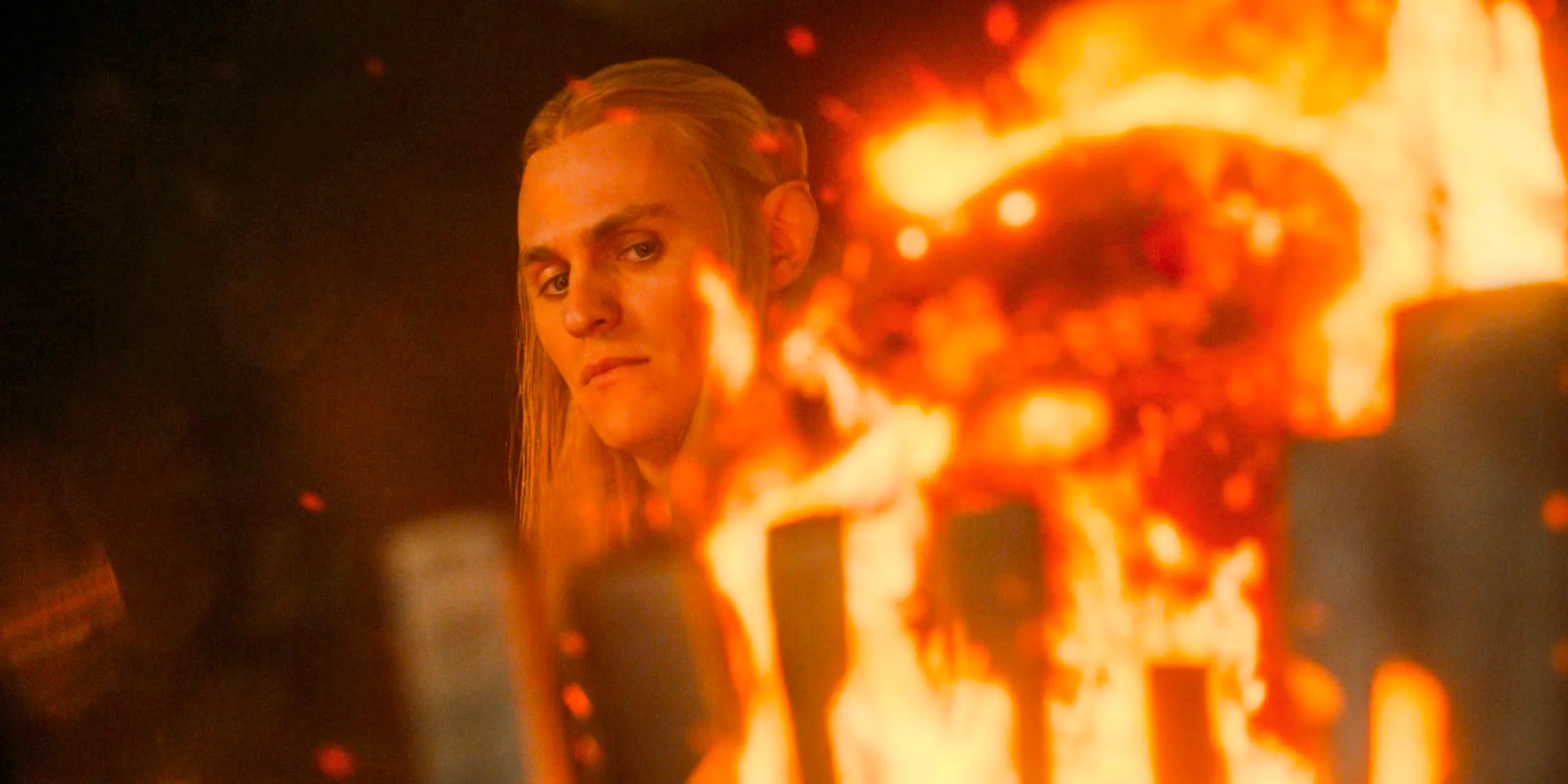 Sauron (Charlie Vickers) staring intently into the fire in The Lord of the Rings: The Rings of Power Season 2 Episode 6 Image