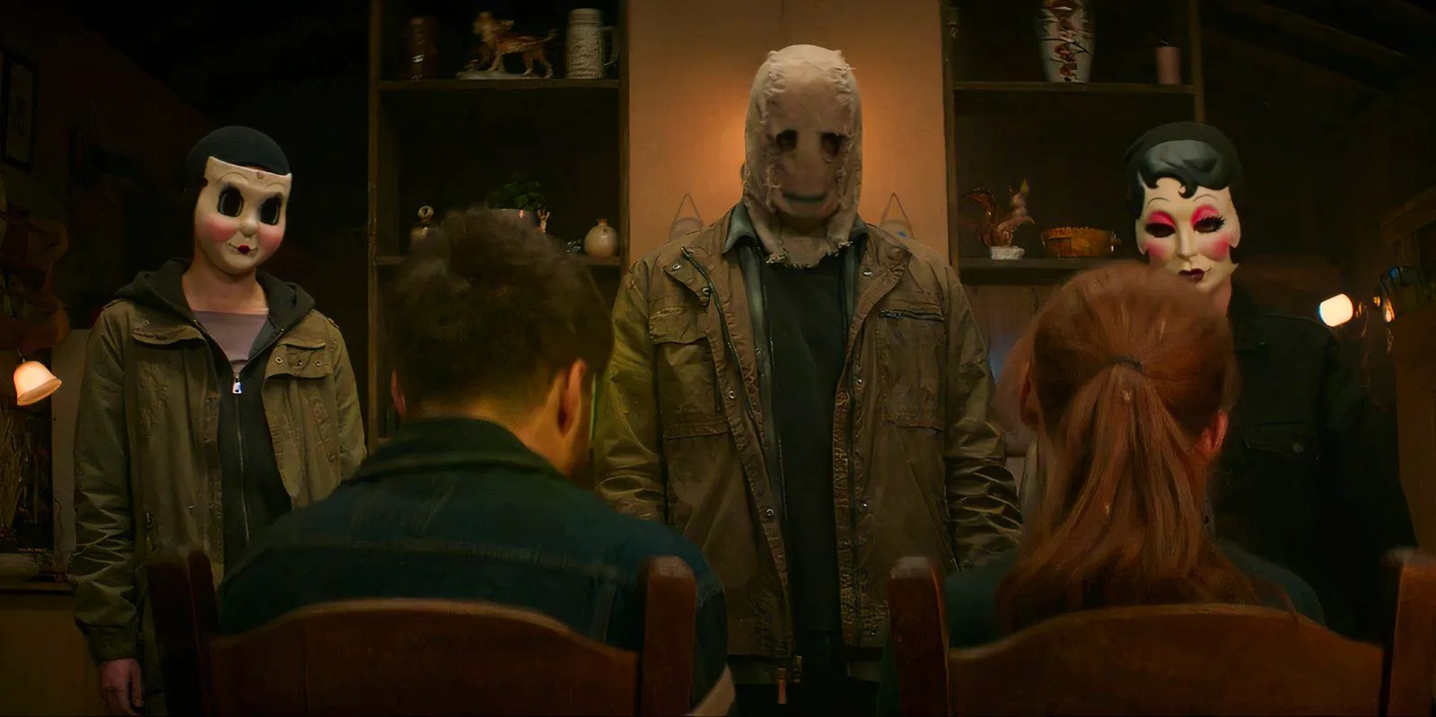 Scarecrow, Pin-Up Girl, and Dollface watch Maya and Ryan in The Strangers: Chapter 1. Image