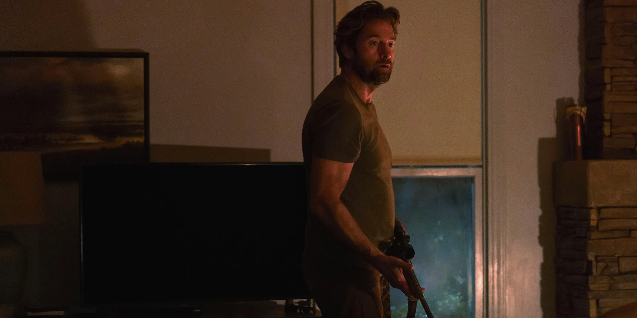 Scott Speedman as James looking concerned while holding a rifle in Teacup Image