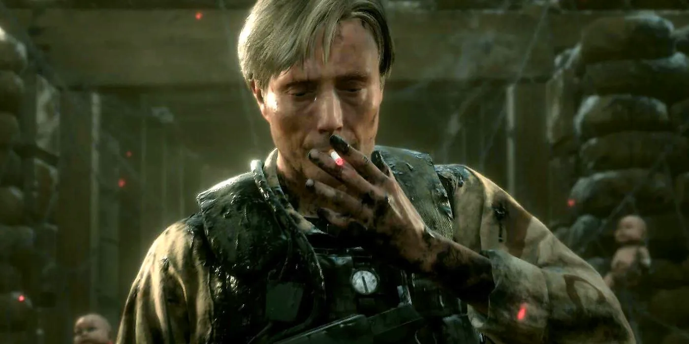 Screenshot of Mads Mikkelsen's character from Death Stranding in tactical body armor smoking a cigarette. Image