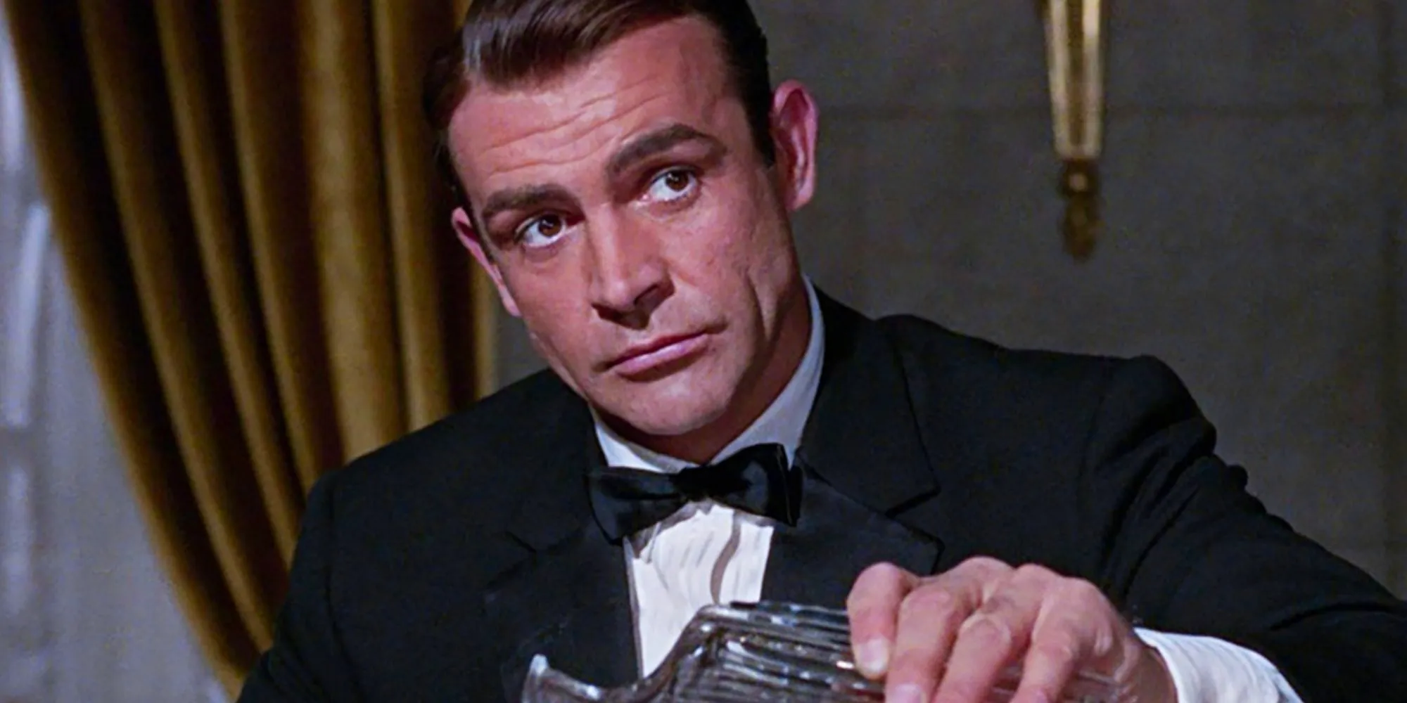 Sean Connery as James Bond pouring himself a drink Image