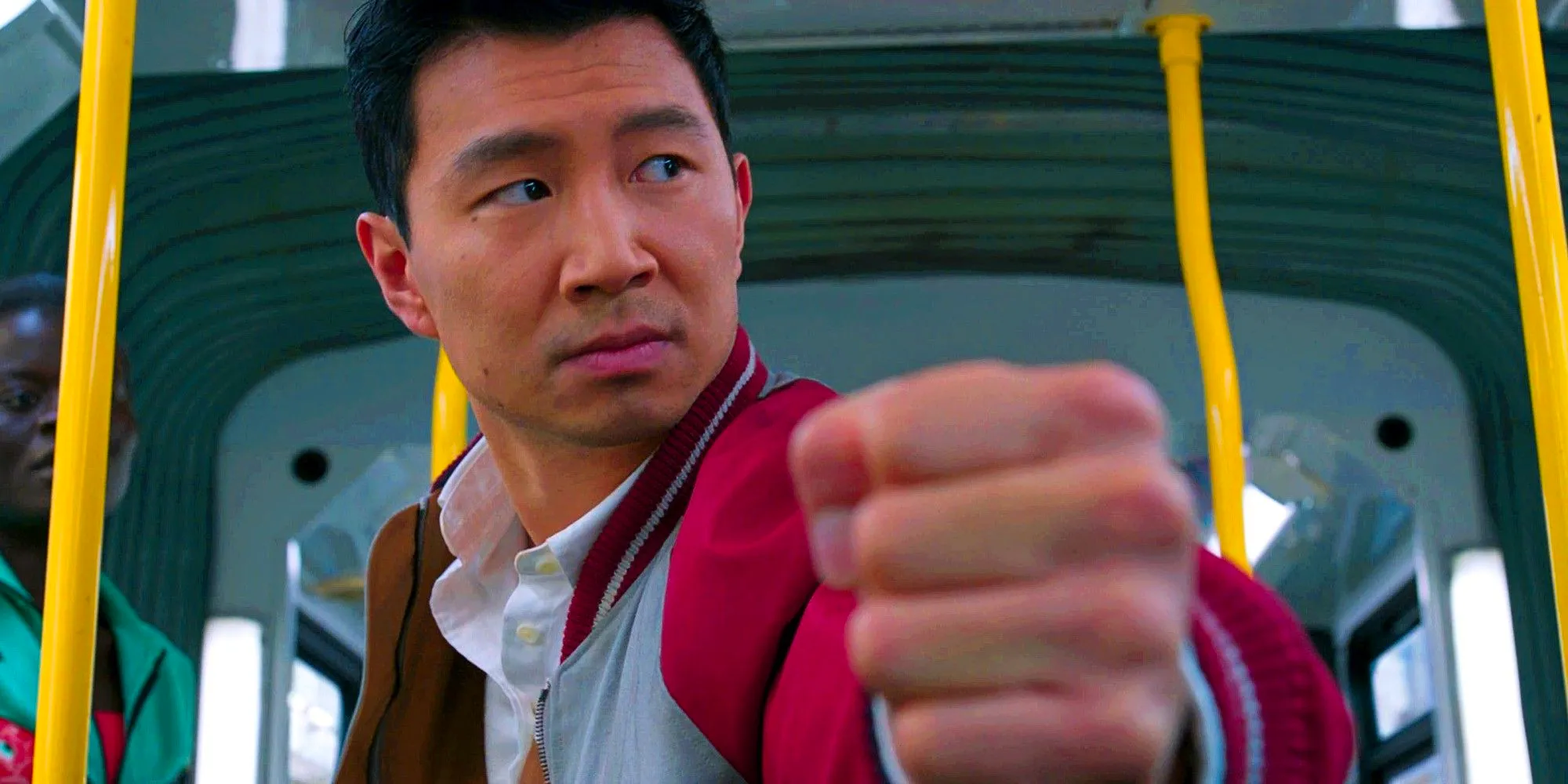 Simu Liu as Shang-Chi With His Fist To The Camera In the Middle Of A Fight On A Bus Image