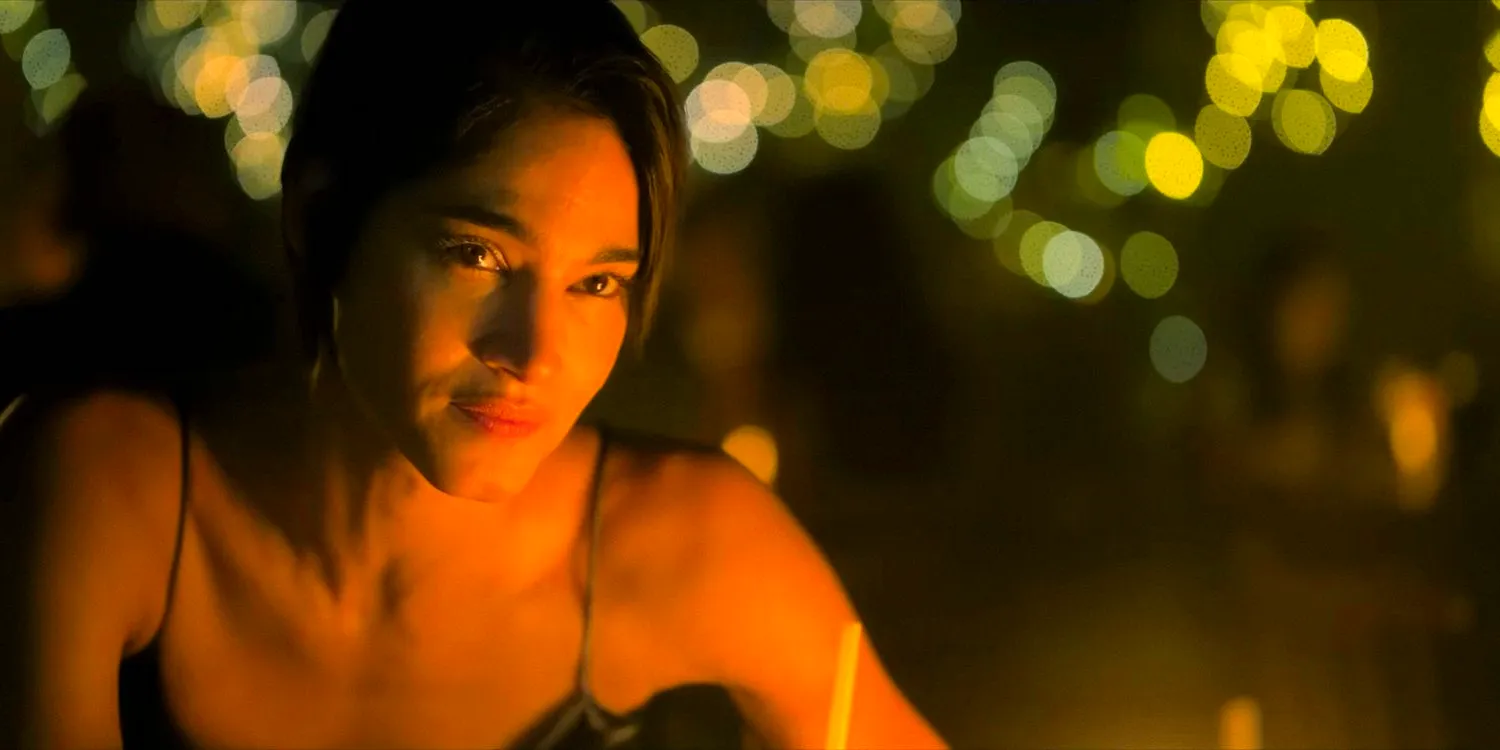 Sofia Boutella as Maize sitting at dinner in The Killer's Game 2024 Image