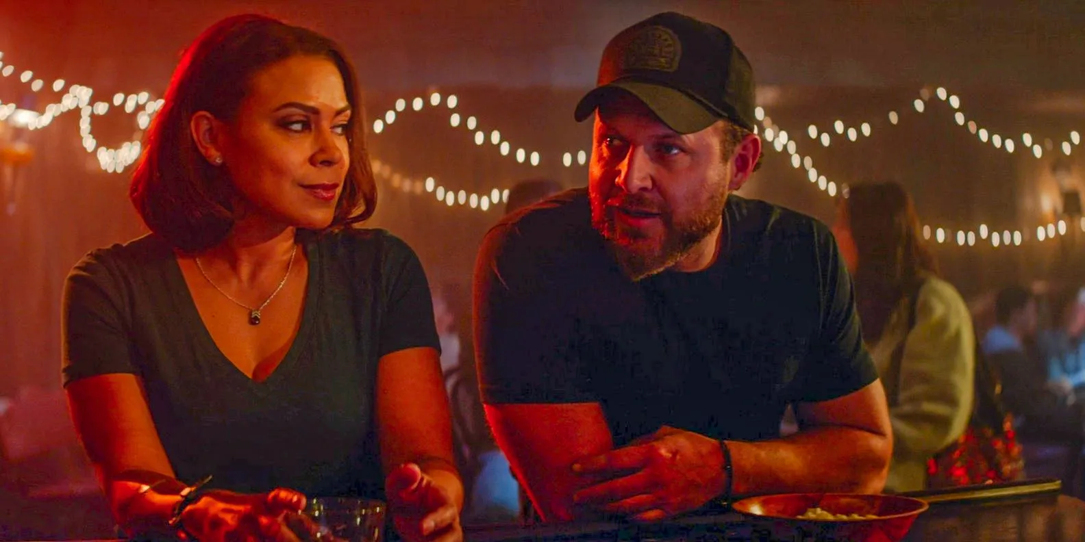 Sonny Quinn (A.J. Buckley) and Lisa Davis (Toni Trucks) chatting in a bar in SEAL Team Season 7 Episode 1 Image