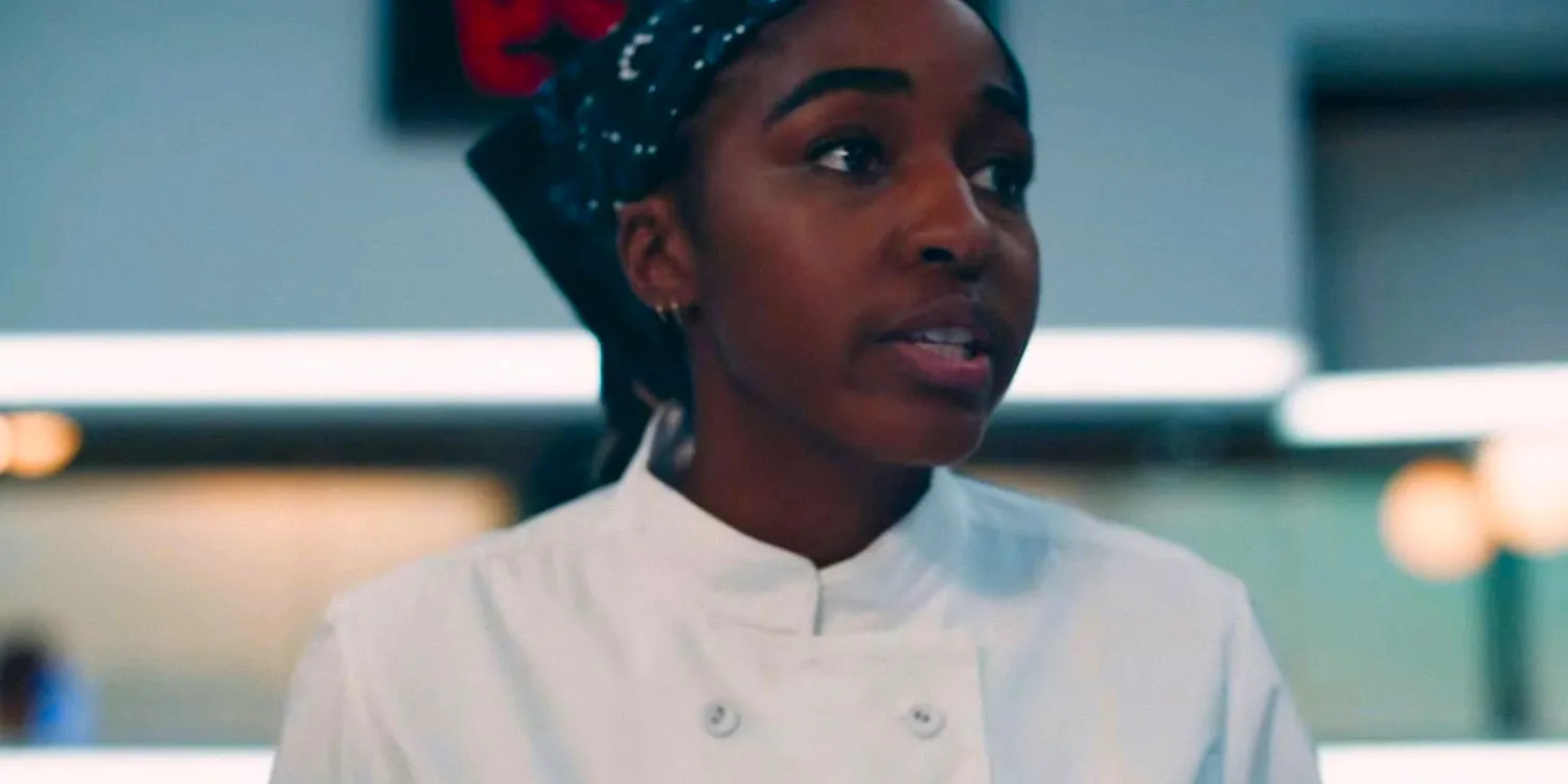 Sydney (Ayo Edebiri) in the restaurant kitchen, looking stressed in The Bear season 3 Image