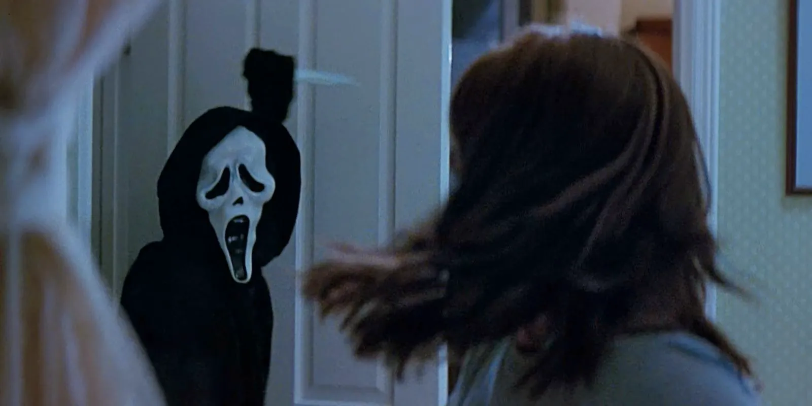 Sydney turns around and sees Ghostface with a knife in Scream. Image