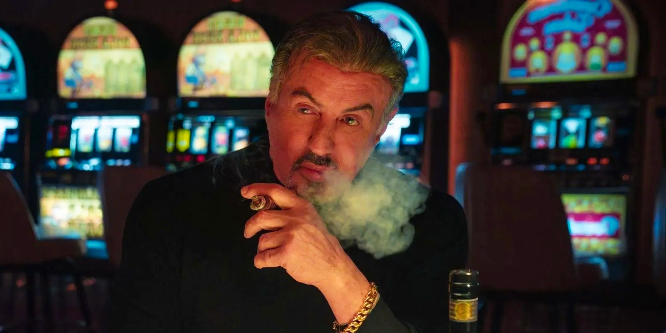 Sylvester Stallone as Dwight Manfredi smoking a cigar at a casino in Tulsa King season 2 Image