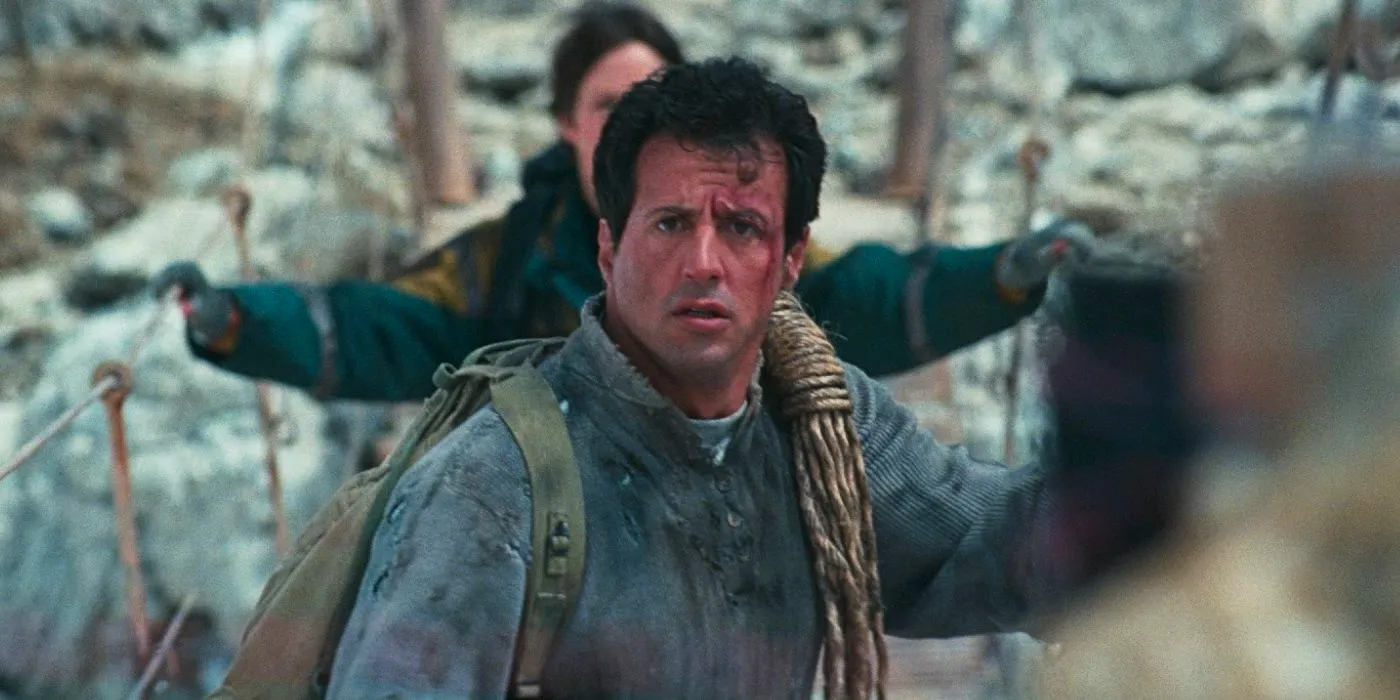 Sylvester Stallone crossing a rope bridge as Gabe Walker looking shocked in Cliffhanger Image