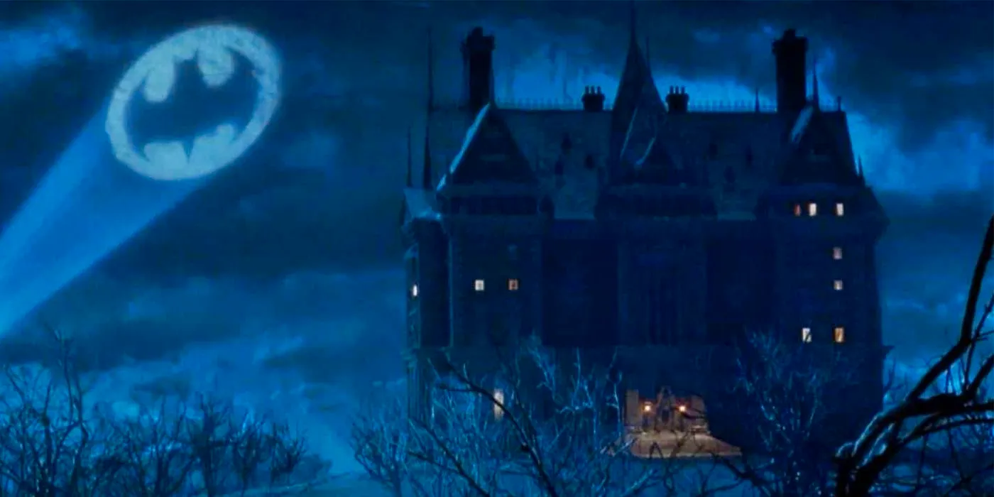 The Batsignal in the night sky next to Wayne Manor in Batman Begins. Image