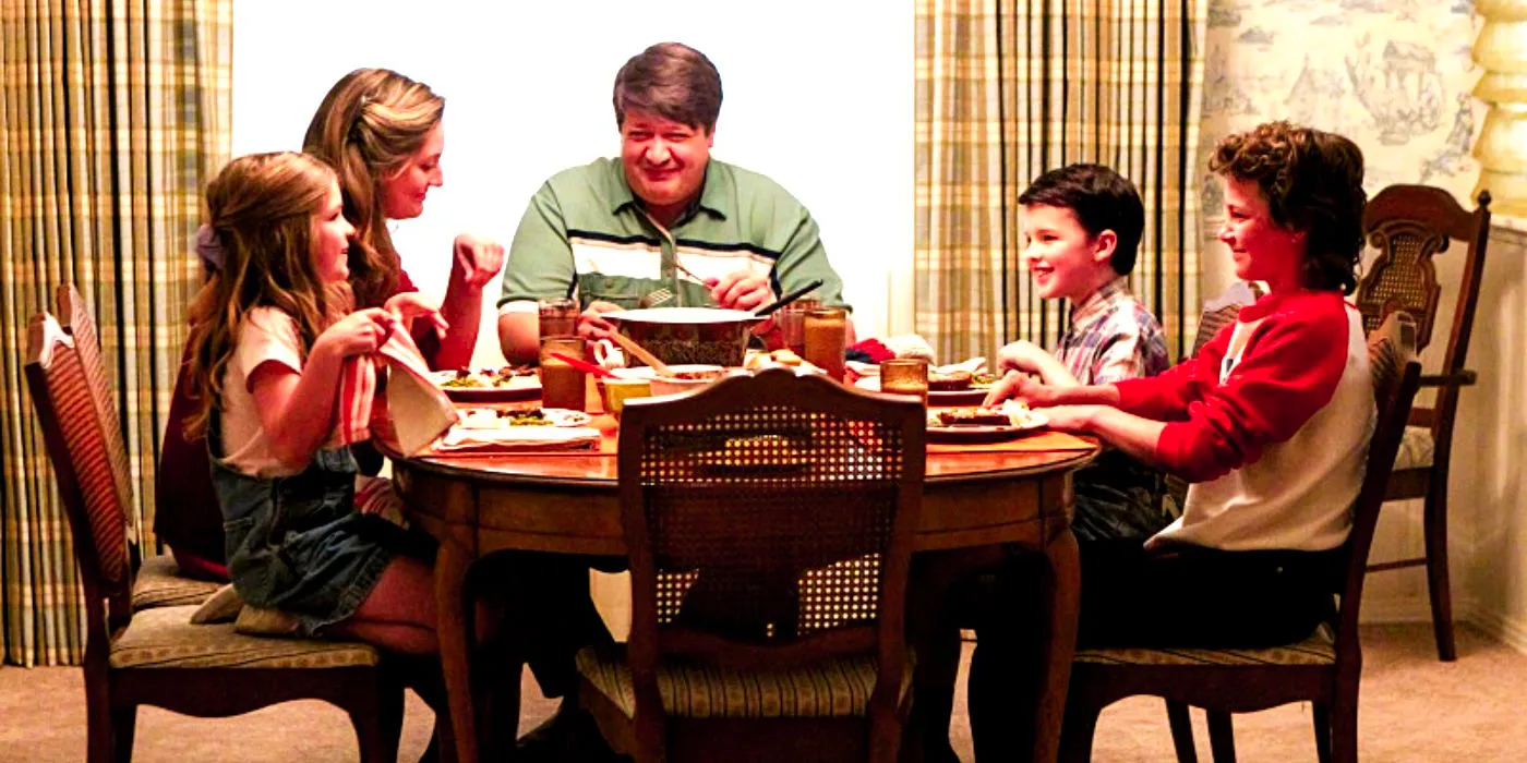 The Coopers sitting around the dinner table and laughing in Young Sheldon Image