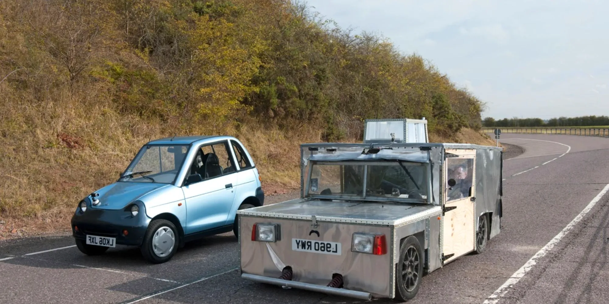 The electric car (Geoff) in Top Gear Season 14, Episode 2 next to a blue car on the road Image