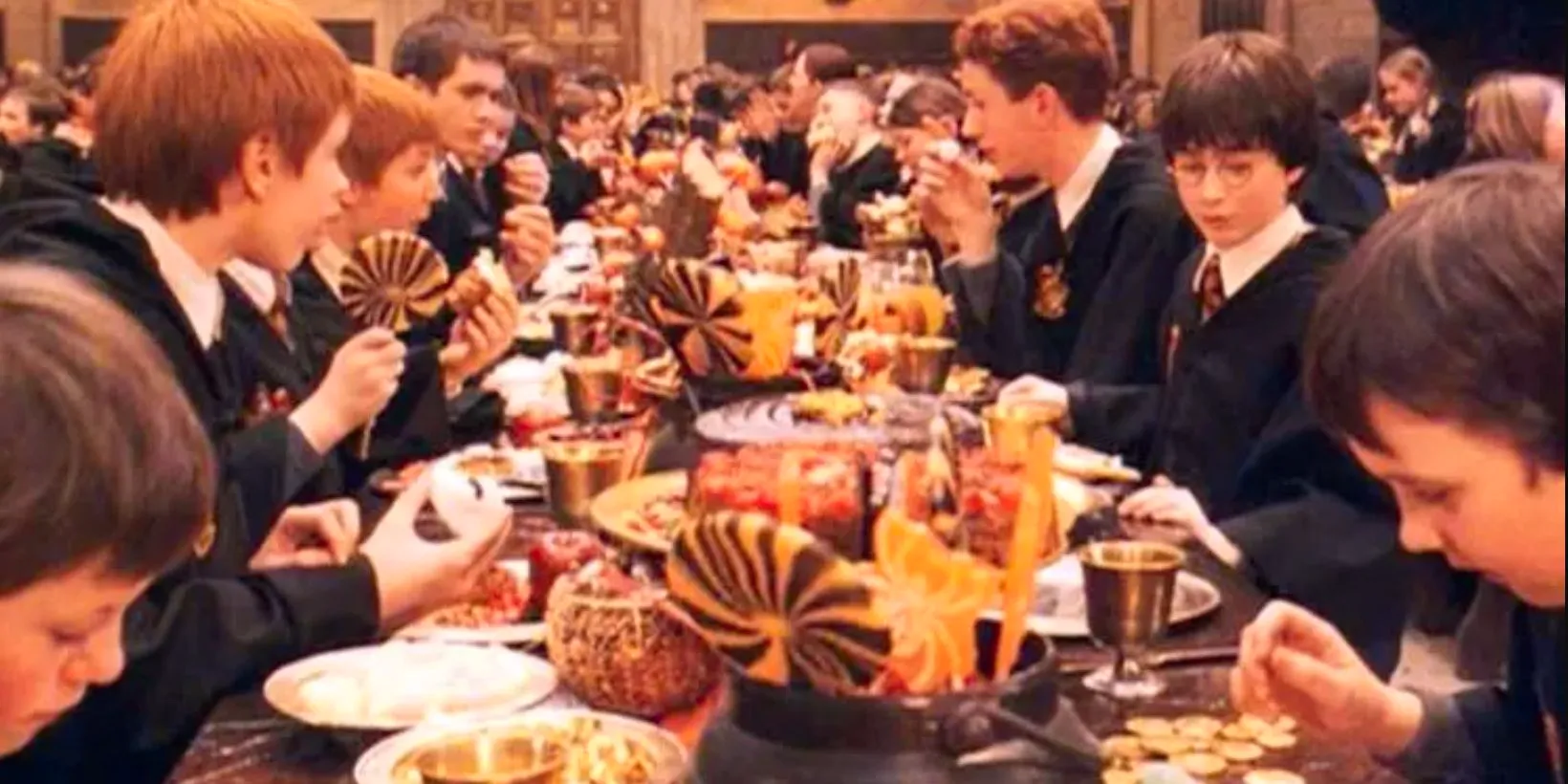 The Gryffindor students at a table laid out for a Halloween feast in the Great Hall in Harry Potter and the Sorcerer's Stone Image