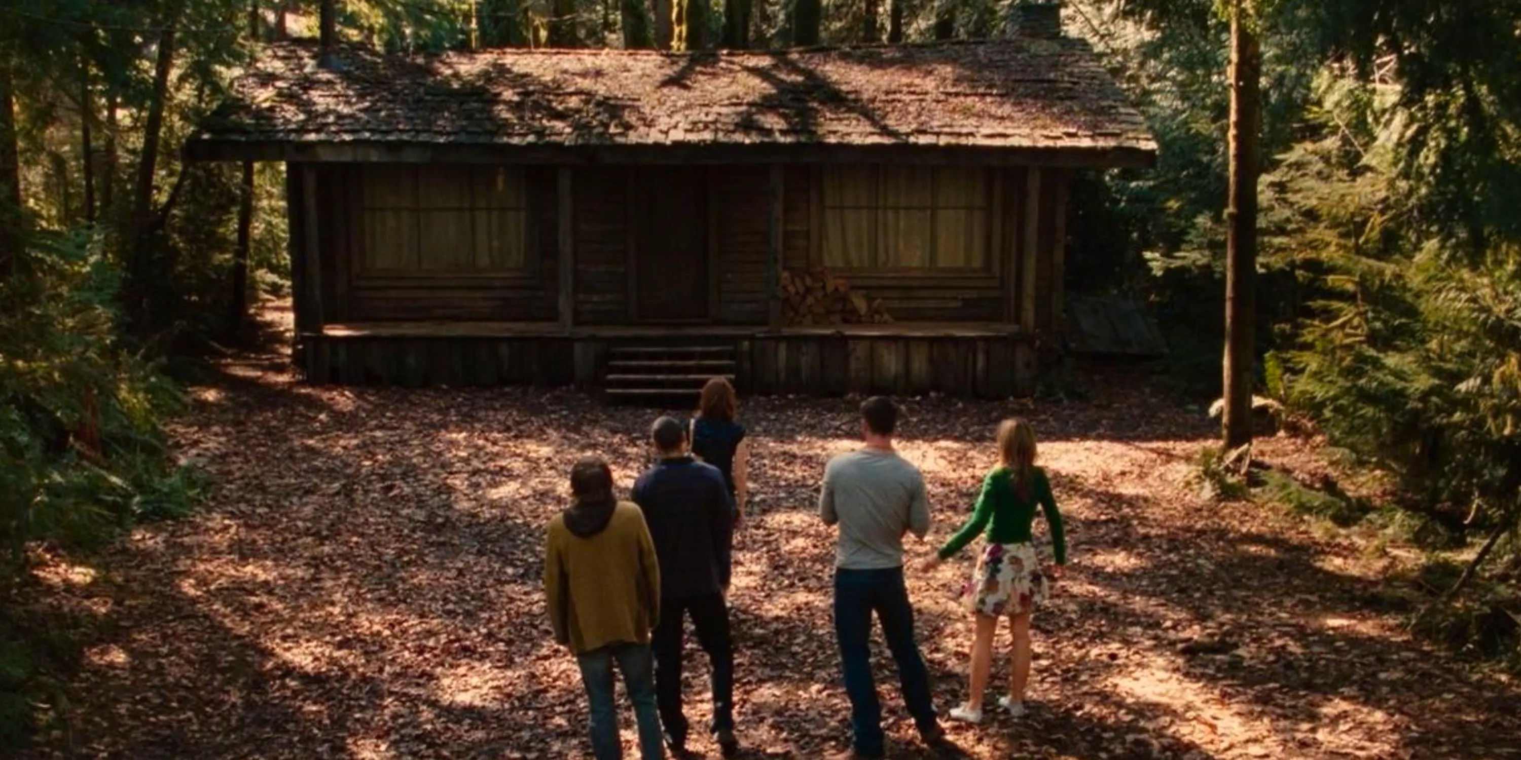 The main characters of The Cabin in the Woods standing outside the cabin and looking at it Image