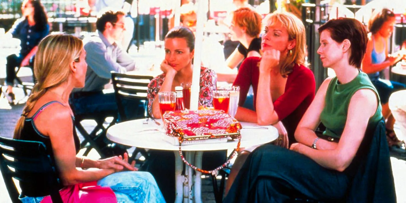 The main Sex and the City cast sitting around an outdoor table Image