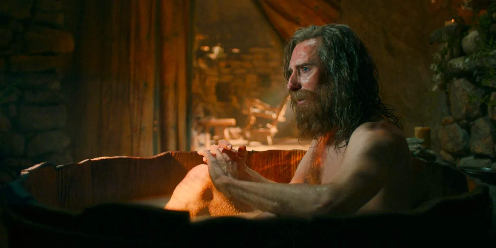 The Stranger (Daniel Weyman) taking a bath in Bombadil's cabin in The Lord of the Rings: The Rings of Power Season 2 Episode 4 Image