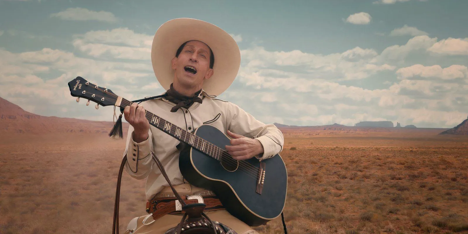 Tim Blake Nelson playing guitar and singing in The Ballad of Buster Scruggs Image