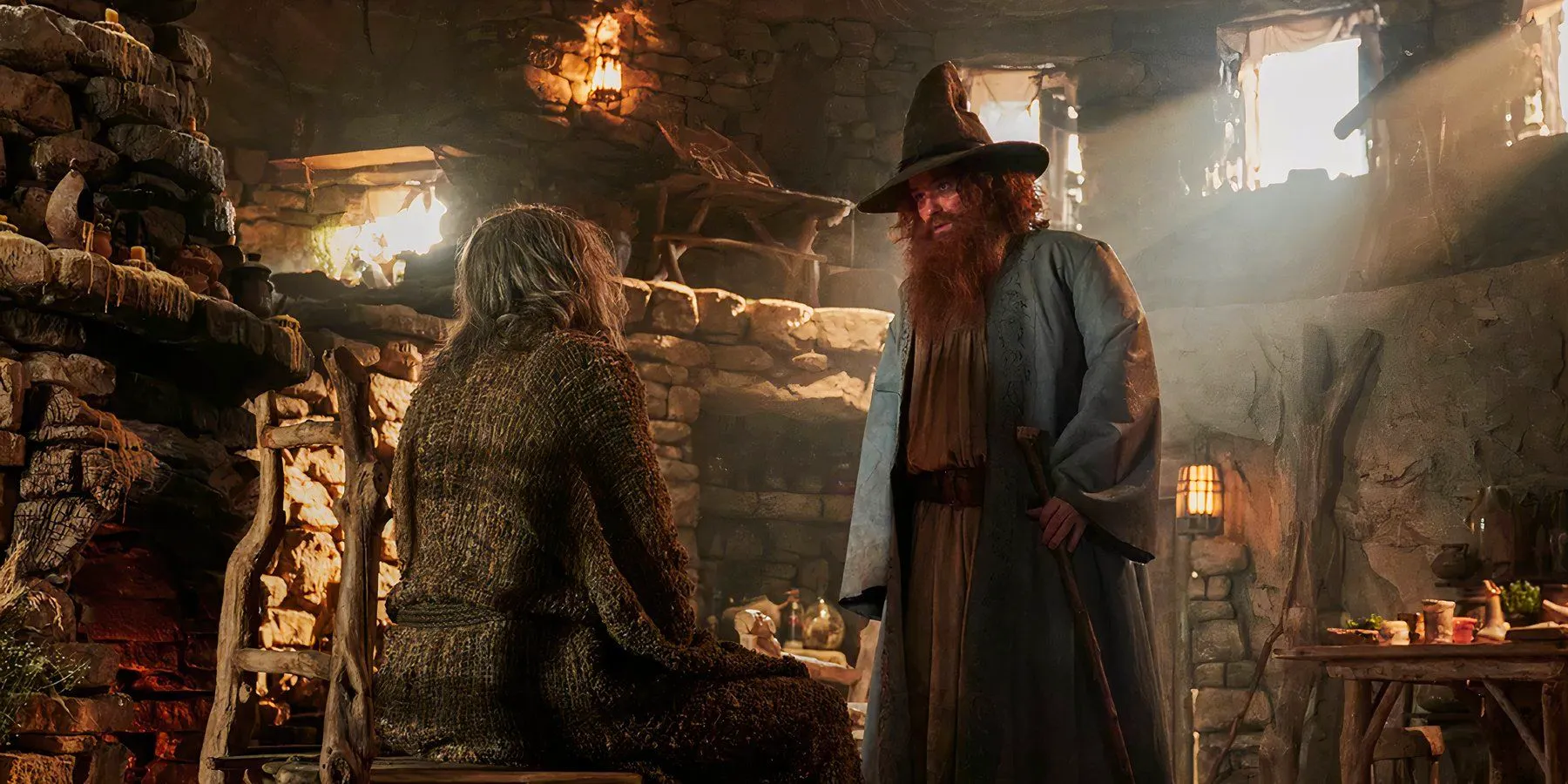 Tom Bombadil (Rory Kinnear) looks down at The Stranger (Daniel Weyman) in The Lord of the Rings The Rings of Power season 2 Image