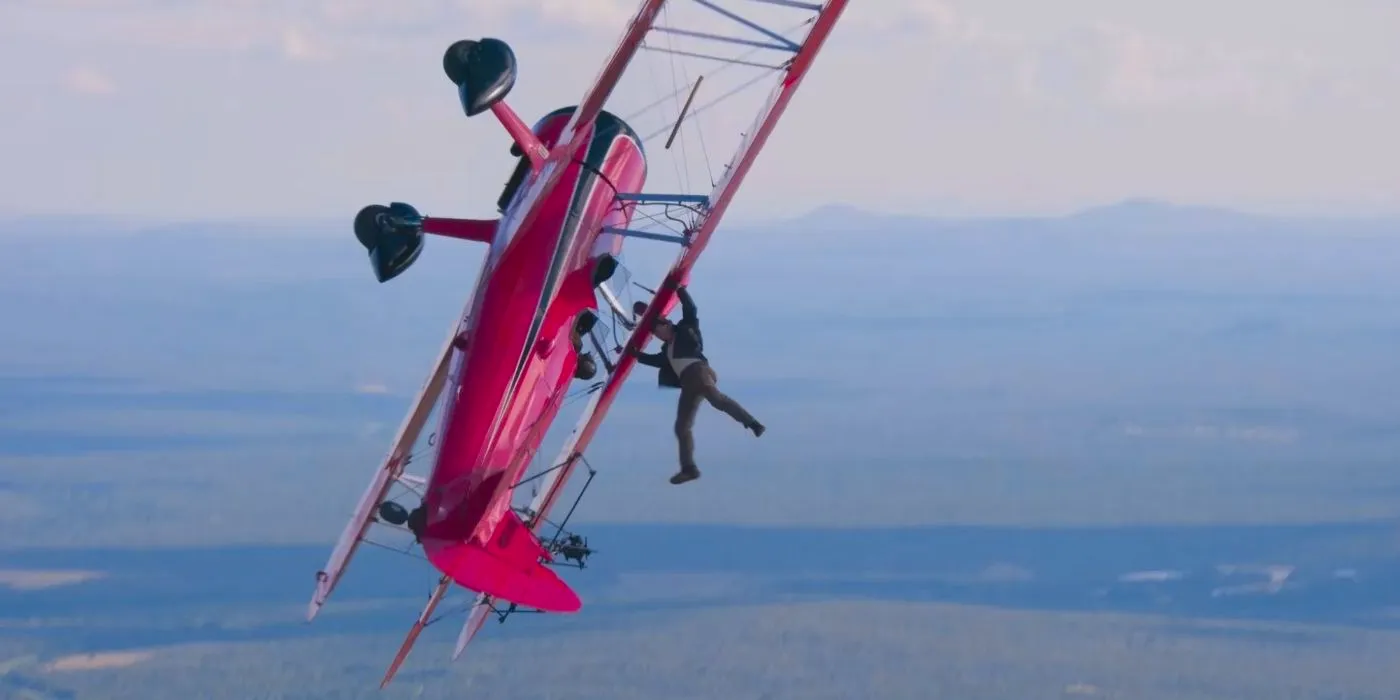 Tom Cruise hanging upside down from a biplane. Image