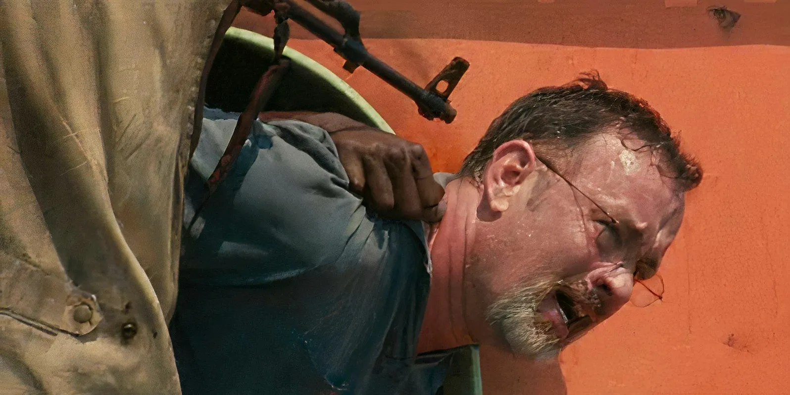 Tom Hanks as Richard Phillips with a gun to his head in a lifeboat in Captain Phillips Image