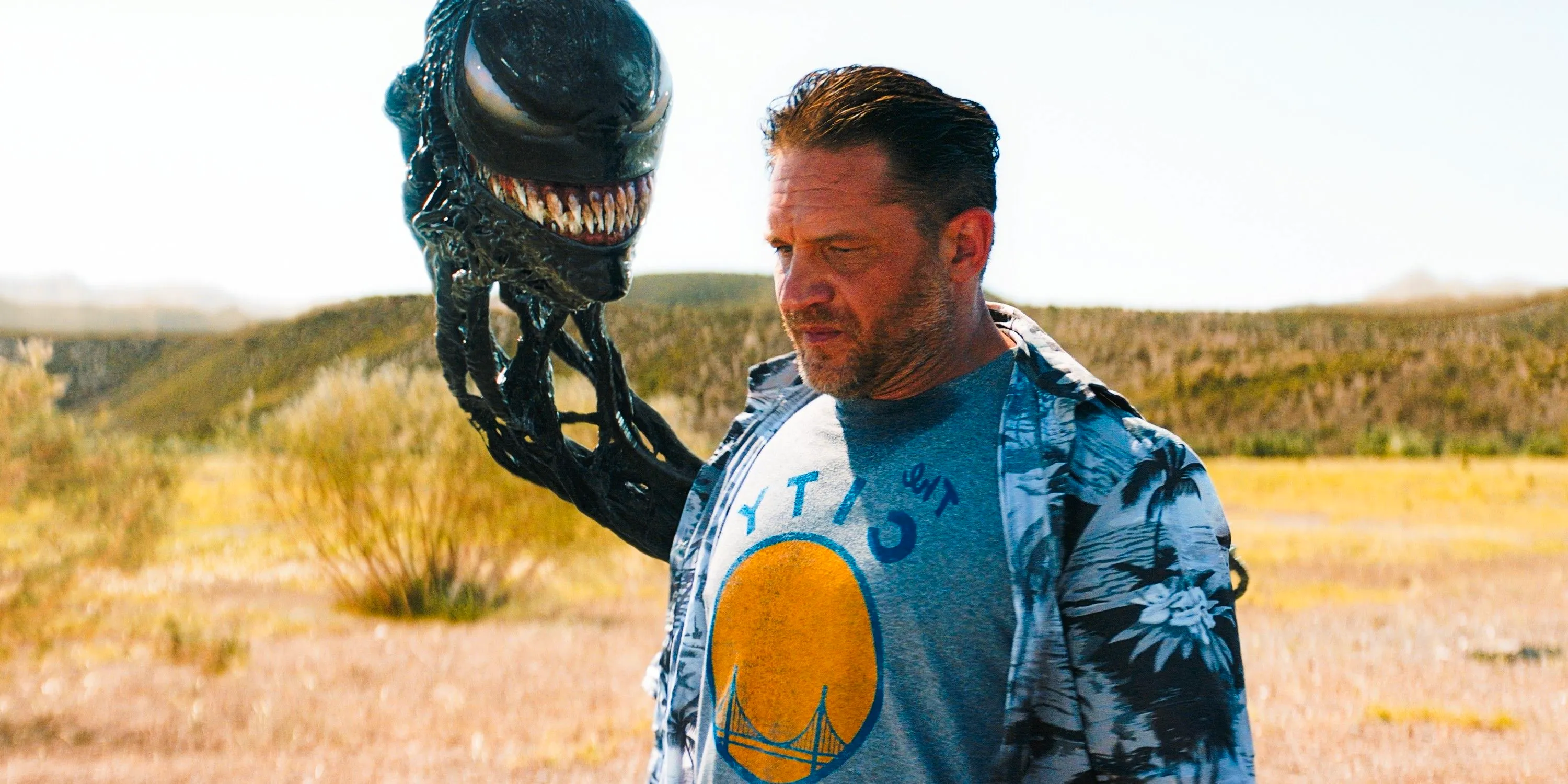 Tom Hardy As Eddie Brock With Venom Symbiote Head Emerging From His Back In A Prairie In Venom The Last Dance Image