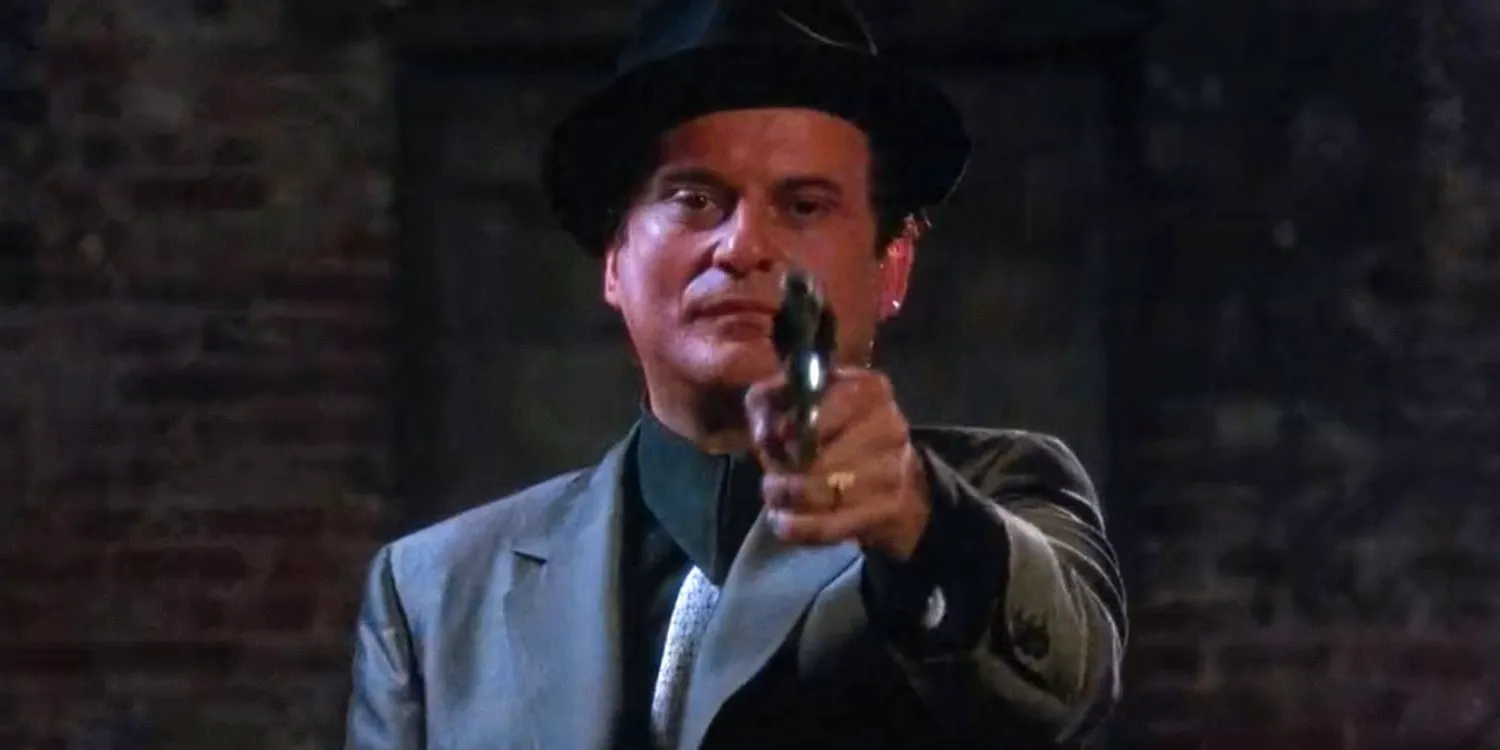 Tommy pointing a gun towards the camera in Goodfellas Image