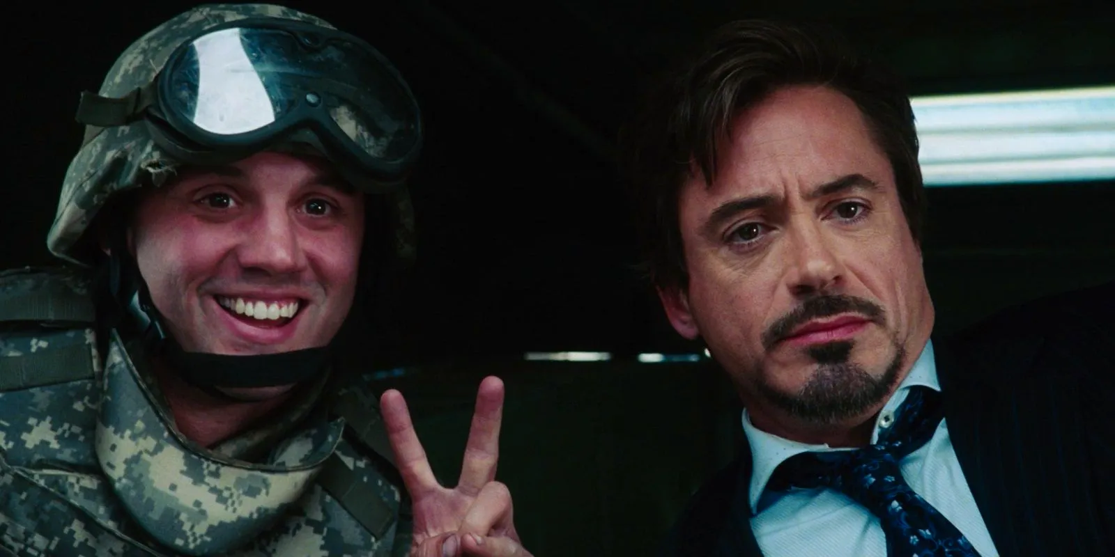 Tony takes a photo with a soldier in Iron Man Image