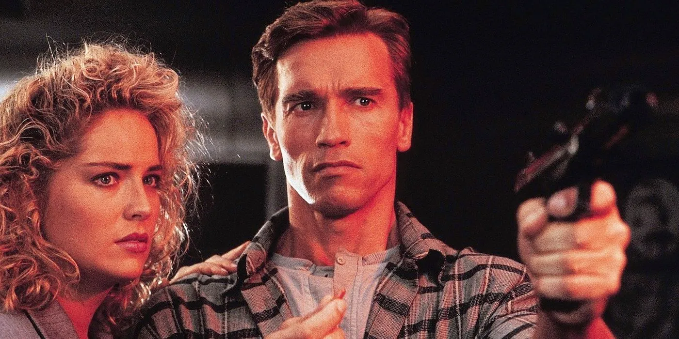 Total Recall's Arnold Schwarzenegger and Sharon Sharon, Arnold pointing a gun just off camera Image