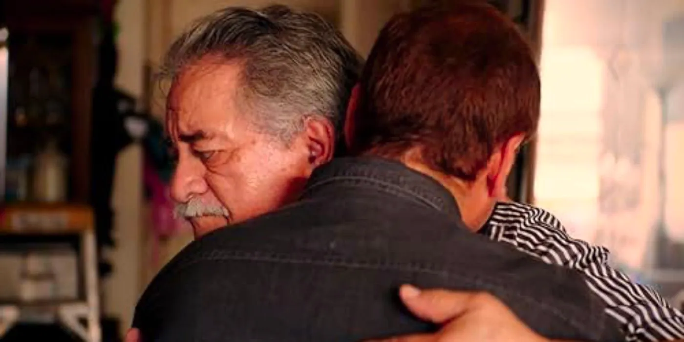 Two men embrace in Menendez + Menudo  Image