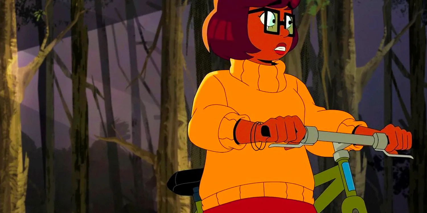 Velma frightened in the middle of the woods with her bicycl in Velma season 2 ep 1 Image