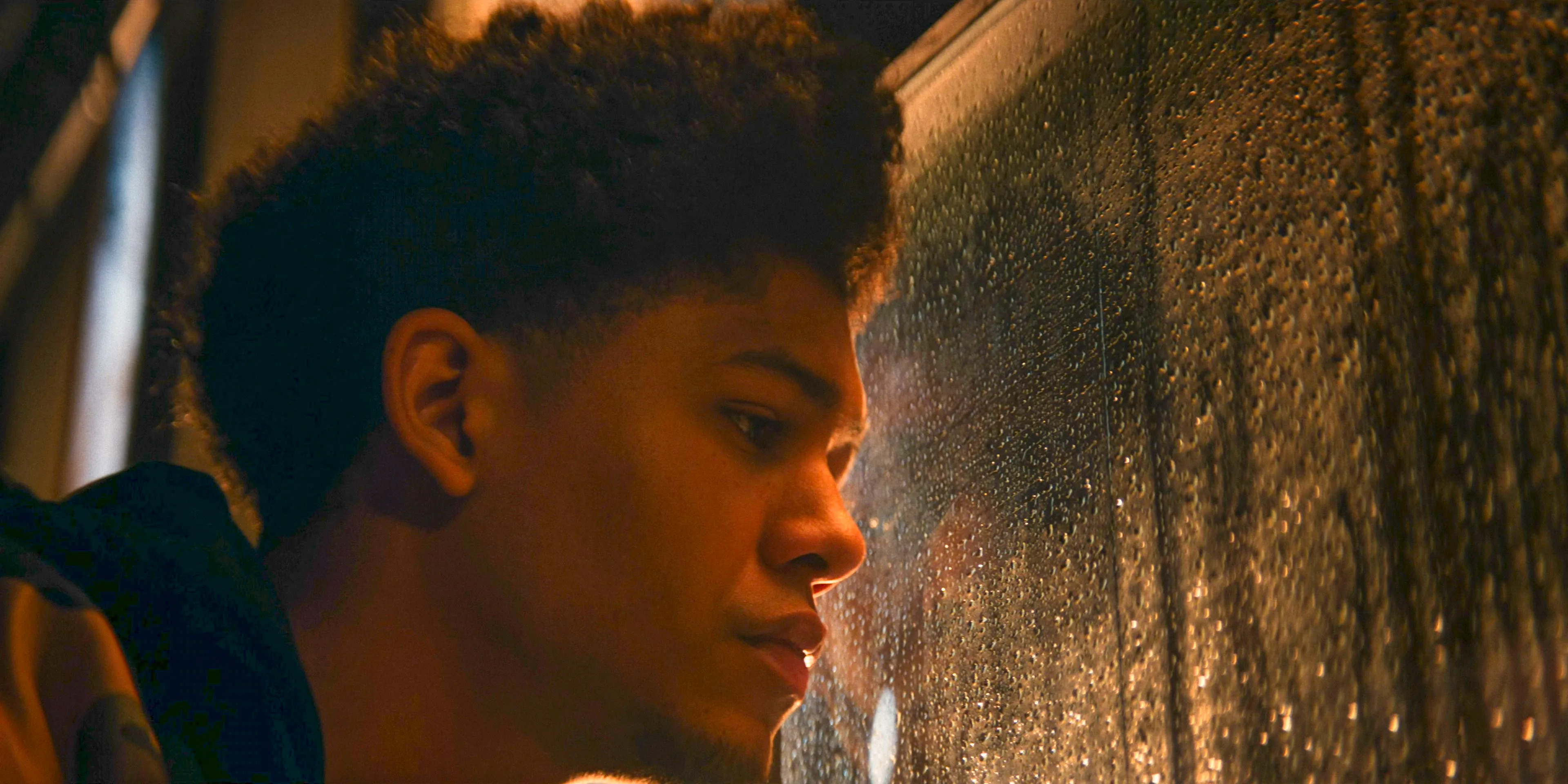 Victor (Rhenzy Feliz) looking nostalgically out the window, remembering the death of his parents in The Penguin Season 1 Episode 3 Image