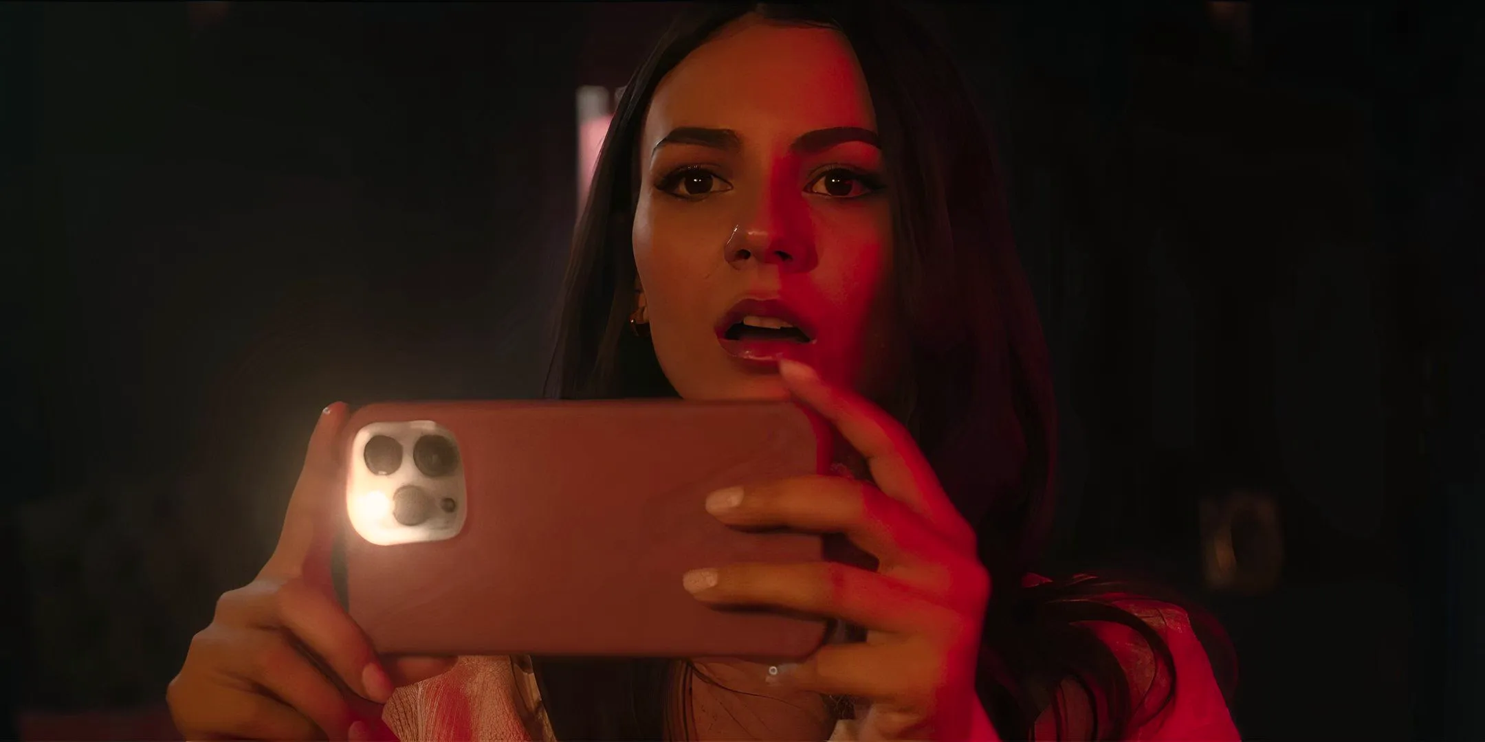 Victoria Justice's Grace looking surprised while filming something on her phone in Depravity Image