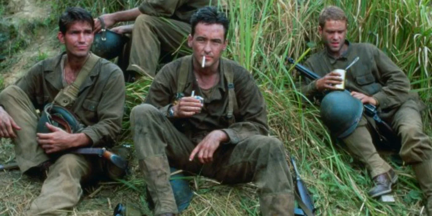 Welsh smoking a cigarette in the grass with other solidiers in The Thin Red Line Image