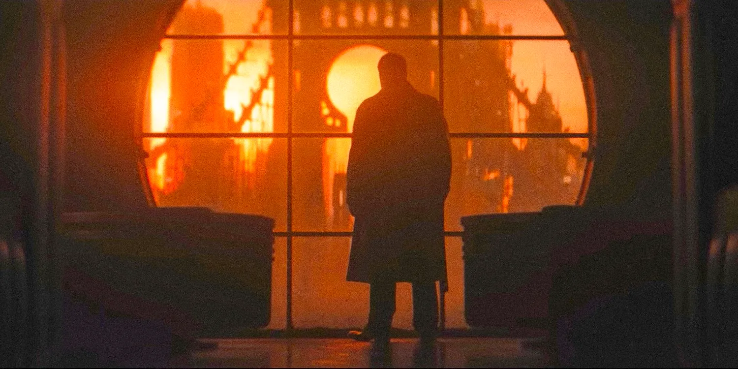 Wide shot of the Penguin contemplating a sunset in Gotham City through a large circular window in The Penguin official teaser Image