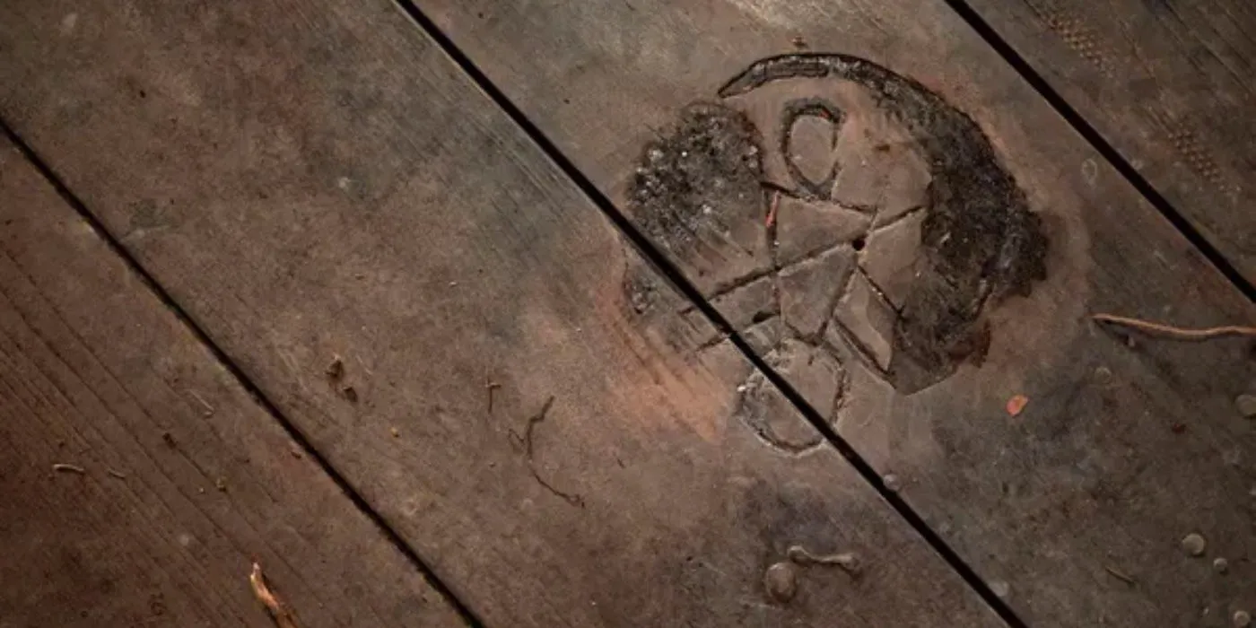 Yellowjackets Symbol carved into a floorboard Image