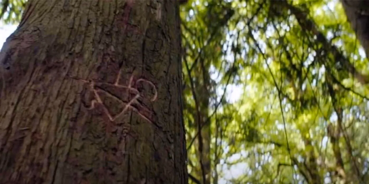 Yellowjackets symbol carved into a tree Image